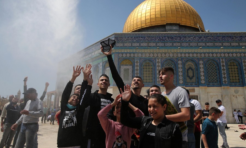 Muslims are sprayed with water in front of the Dome of the Rock in the compound known to Muslims as Noble Sanctuary and to Jews as Temple Mount in Jerusalem's Old City during the holy month of Ramadan on April 16, 2021.(Photo: Xinhua)