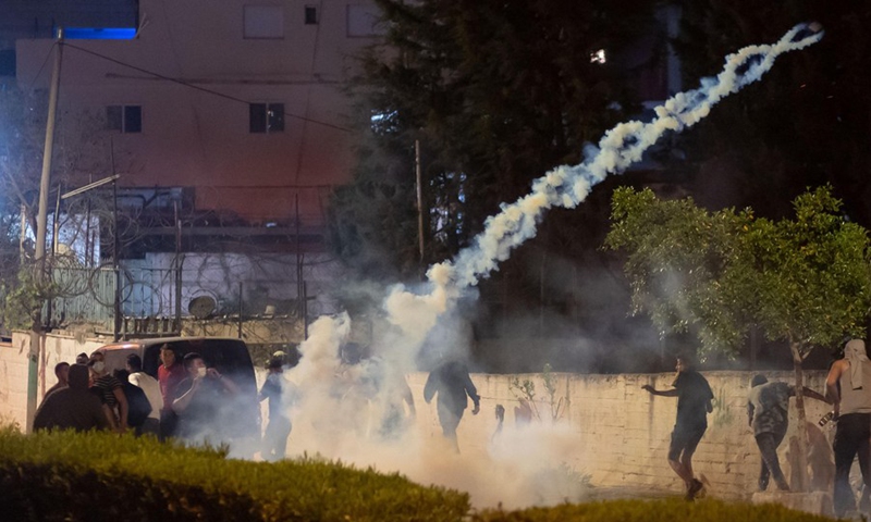 Palestinians run to take cover from tear gas during clashes with Israeli soldiers in the West Bank city of Bethlehem, on April 23, 2021.(Photo: Xinhua)