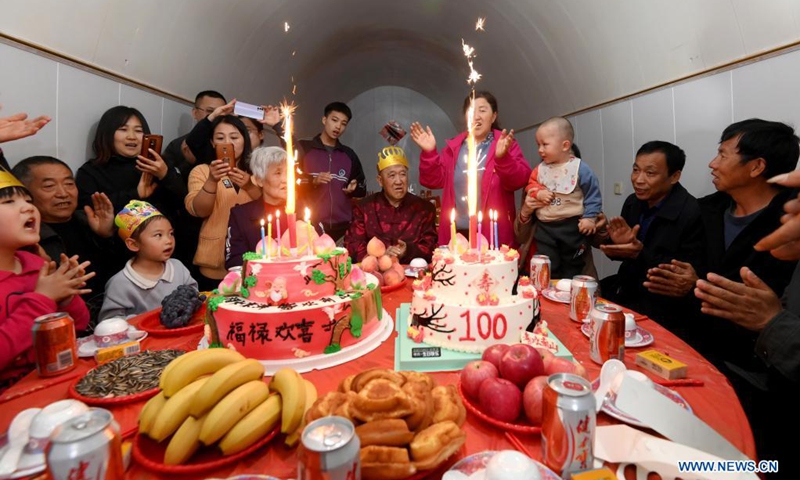 Hu Zaizhong hears family members singing birthday song at his birthday banquet at Xuejiawan Village, Liulin County, Lyuliang City of north China's Shanxi Province, on April 24, 2021. Hu Zaizhong, who has just turned 100, vividly remembers his wishes at different stages of his life: having decent food and clothing in his early days, teaching as many pupils as he could in his prime age, and enjoying quality time with his family for late years.(Photo: Xinhua)
