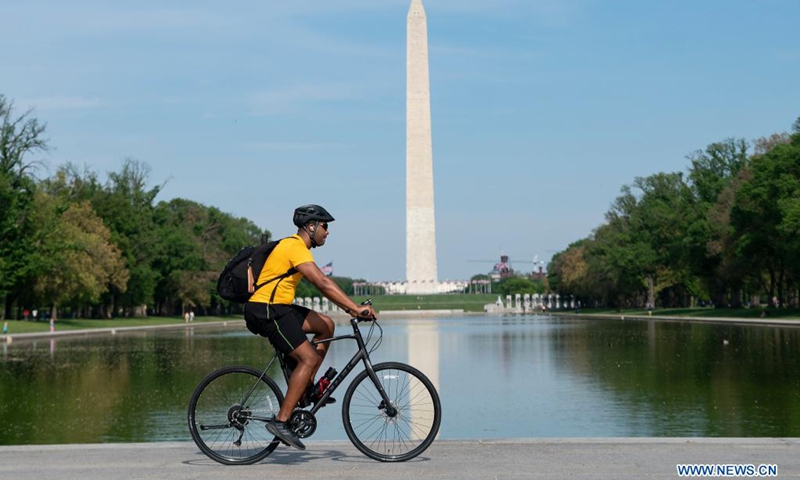 A man rides a bicycle past the Lincoln Memorial Reflecting Pool in Washington, D.C., the United States, on April 27, 2021. The U.S. Centers for Disease Control and Prevention (CDC) unveiled new guidelines for fully vaccinated Americans on Tuesday, including activities they can safely resume without wearing masks.(Photo: Xinhua)