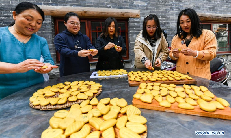 Family members prepare snacks for Hu Zaizhong's birthday banquet at Xuejiawan Village, Liulin County, Lyuliang City of north China's Shanxi Province, on April 24, 2021. Hu Zaizhong, who has just turned 100, vividly remembers his wishes at different stages of his life: having decent food and clothing in his early days, teaching as many pupils as he could in his prime age, and enjoying quality time with his family for late years.(Photo: Xinhua)