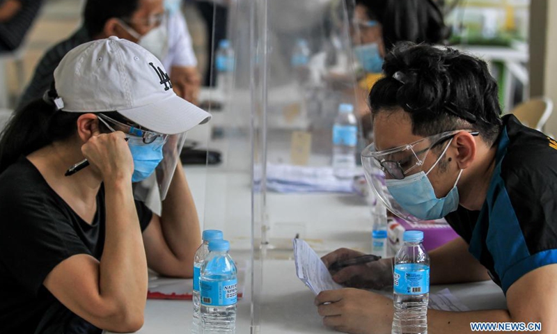 People wearing protective masks are screened before getting inoculated with the Sinovac COVID-19 vaccines in Manila, the Philippines on May 1, 2021.Photo:Xinhua