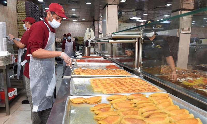 Workers of a restaurant make traditional dessert during the Islamic holy month of Ramadan, in Hawalli Governorate, Kuwait, April 30, 2021.Photo:Xinhua