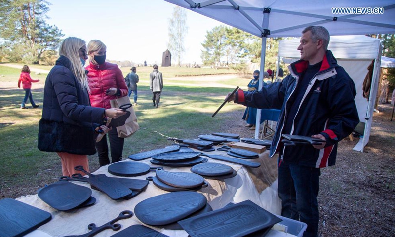 A vendor sells traditional Latvian wood crafts at a spring market in Riga, Latvia, on May 1, 2021.  Photo: Xinhua