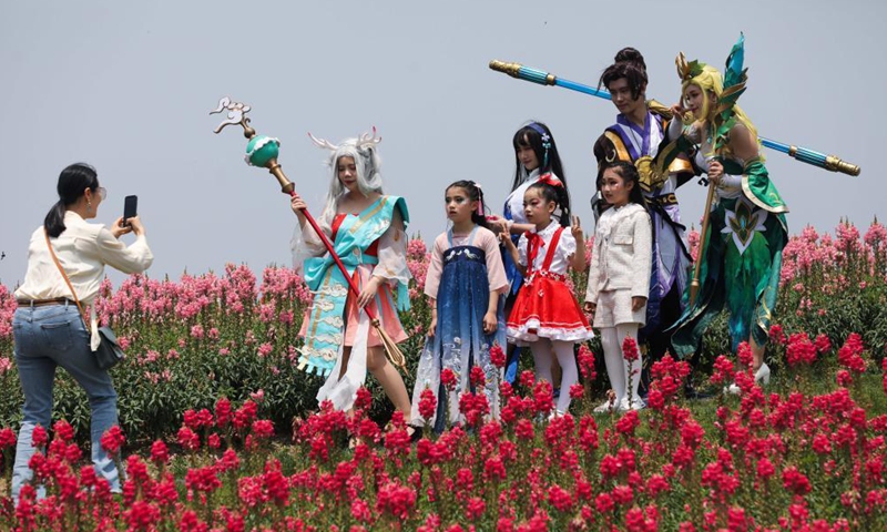 Visitors pose for photos with cosplayers in the flower fields in Jingshan Township of Yuhang District in Hangzhou, capital of east China's Zhejiang Province, May 2, 2021. From May 1 to May 5, an animation carnival is held at the flower fields at the Jingshan Town of Yuhang District of Hangzhou. (Xinhua/Xu Yu)