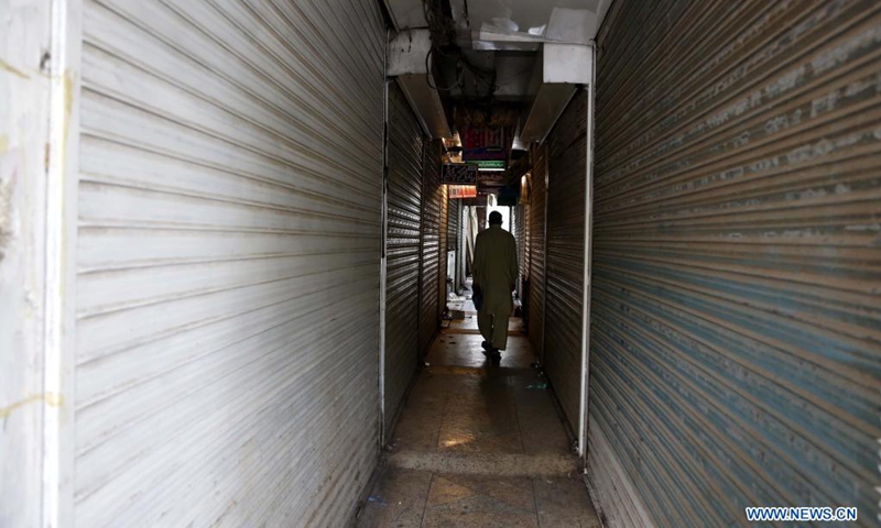 A man walks at a market in Islamabad, capital of Pakistan, on May 8, 2021. In its efforts to curb the third wave of COVID-19, the Pakistani government has ramped up restriction across the country for the upcoming holidays of Eid al-Fitr festival, urging the public to stay at home to keep themselves and their loved ones safe.(Photo: Xinhua)