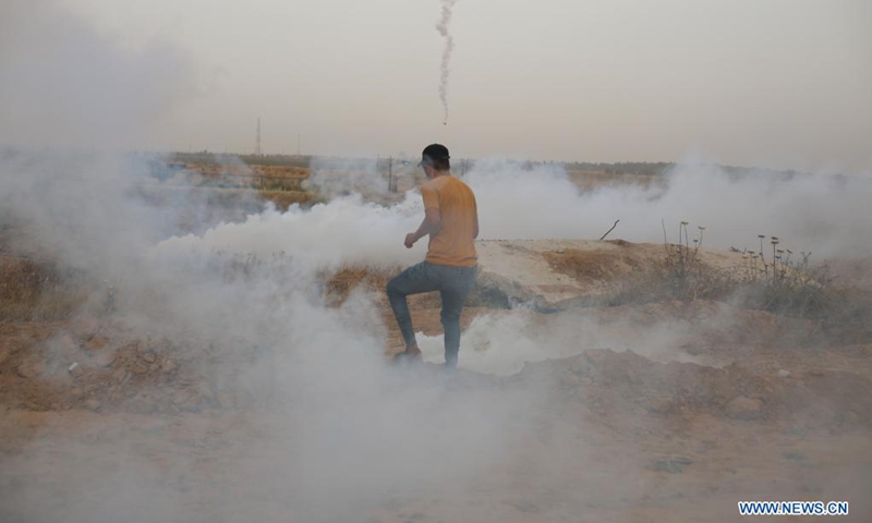A Palestinian protester runs to take cover from tear gas canisters fired by Israeli troops during a protest against the violence in Jerusalem, on the Gaza-Israel border east of southern Gaza Strip city of Khan Younis, on May 9, 2021. About 290 Palestinians were injured over the weekend in clashes with Israel's police at the Al-Aqsa Mosque compound and other parts of East Jerusalem.(Photo: Xinhua)