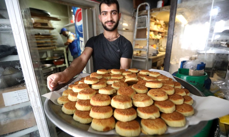 A Ma'amoul maker displays just-baked Ma'amoul cookies at a sweet shop in Beirut, Lebanon, on May 9, 2021.(Photo: Xinhua)