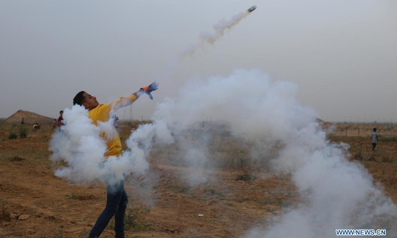 A Palestinian protester throws back a tear gas canister during a protest against the violence in Jerusalem, on the Gaza-Israel border east of southern Gaza Strip city of Khan Younis, on May 9, 2021. About 290 Palestinians were injured over the weekend in clashes with Israel's police at the Al-Aqsa Mosque compound and other parts of East Jerusalem.(Photo: Xinhua)
