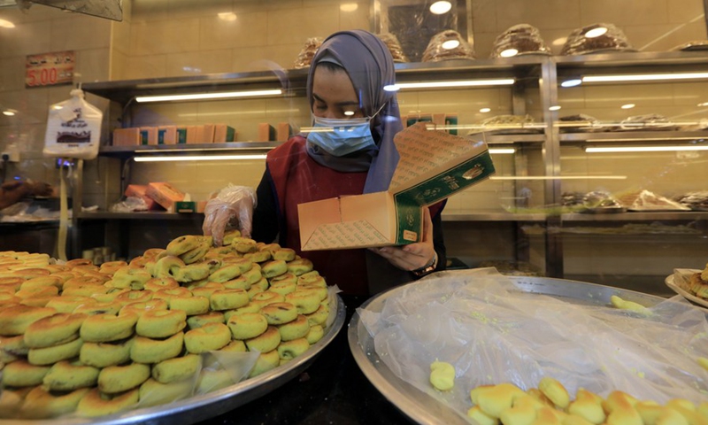 A vendor packages traditional sweets ahead of the Eid al-Fitr that marks the end of the Islamic holy month of Ramadan, at a shop in Amman, capital of Jordan, on May 12, 2021.(Photo: Xinhua)