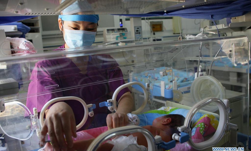 A nurse takes care of a newborn baby at the neonatal intensive care unit (NICU) in a hospital in Qujing City, southwest China's Yunnan Province, May 12, 2021. China had more than 4.7 million registered nurses by the end of 2020, the National Health Commission said on International Nurses Day, which falls on Wednesday.(Photo: Xinhua)