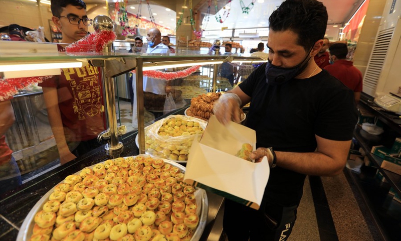 A vendor packages traditional sweets ahead of the Eid al-Fitr that marks the end of the Islamic holy month of Ramadan, at a shop in Amman, capital of Jordan, on May 12, 2021.(Photo: Xinhua)