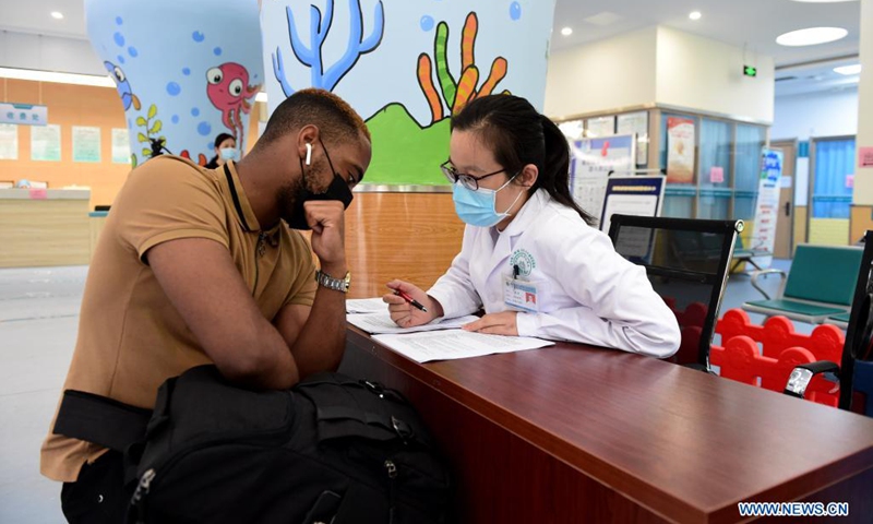 A medical worker learns about a foreigner's medical history before vaccination at a vaccination site in Hefei, capital of east China's Anhui Province, May 12, 2021. Anhui has recently started COVID-19 vaccination for foreign nationals in the province. Foreign nationals of appropriate age, following the principle of voluntary participation, giving informed consent and assuming personal responsibility for risk, take the COVID-19 vaccine.(Photo: Xinhua)