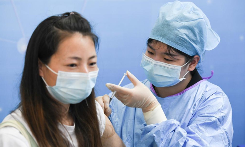 A woman receives a dose of COVID-19 vaccine at a vaccination site in Shushan District of Hefei, east China's Anhui Province, May 15, 2021. Since Friday morning, residents in Hefei have queued up at vaccination sites to receive COVID-19 vaccines. Some sites have prolonged their service time or even run around the clock.Photo:Xinhua