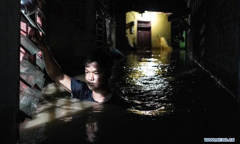 A man walks through flood water due to the overflow of Deli river at Medan in North Sumatra, Indonesia, on May 15, 2021. Photo:Xinhua