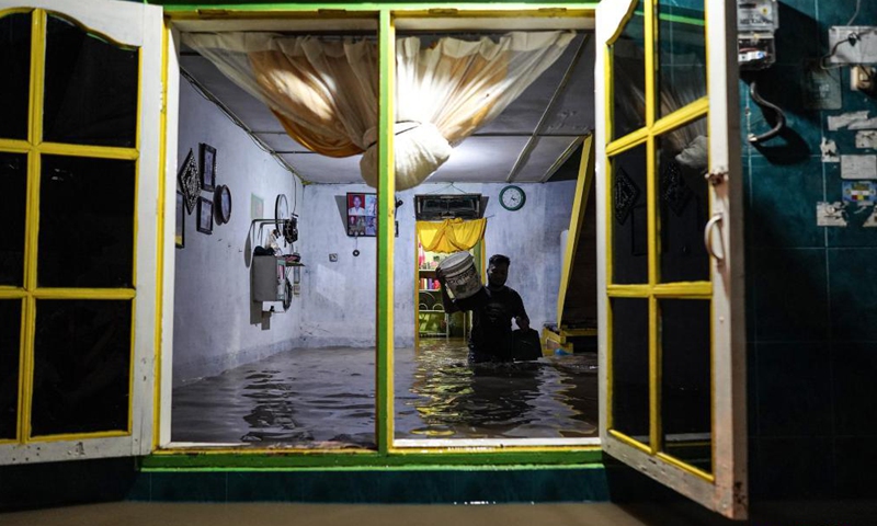 A man walks through flood water in his house due to the overflow of Deli river at Medan in North Sumatra, Indonesia, on May 15, 2021.Photo:Xinhua