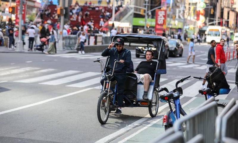 A tour guide rides a rickshaw through Times Square in New York, the United States, May 14, 2021. The U.S. Centers for Disease Control and Prevention (CDC) will no longer recommend masks for fully-vaccinated Americans indoors or outdoors, including in crowds, according to its new guidance announced on Thursday.Photo:Xinhua