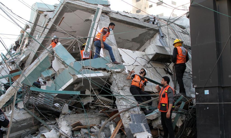 Rescuers check rubbles of Jala Tower, which housed offices of Al-Jazeera TV and Associated Press as well as residential apartments, after it was hit by an Israeli airstrike in Gaza City, on May 15, 2021. Israel said Saturday it struck the high-rise building in Gaza City housing offices of international media outlets because it contained assets of Hamas intelligence agency. (Photo: Xinhua)