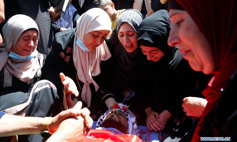 Relatives of Palestinian Yassin Hamad, 25, who was killed during clashes with Israeli soldiers, mourn over his body during his funeral in Seida village, north of the West Bank city of Nablus, May 16, 2021.(Photo: Xinhua)