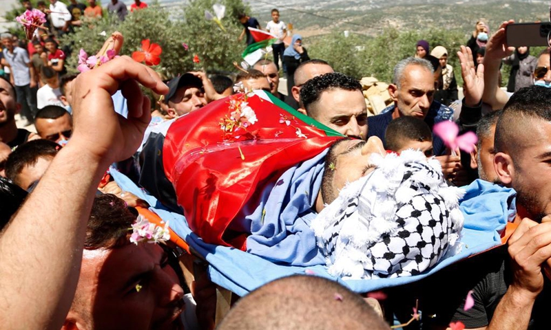 Mourners carry the body of Palestinian Yassin Hamad, 25, who was killed during clashes with Israeli soldiers, during his funeral in Seida village, north of the West Bank city of Nablus, May 16, 2021.(Photo: Xinhua)