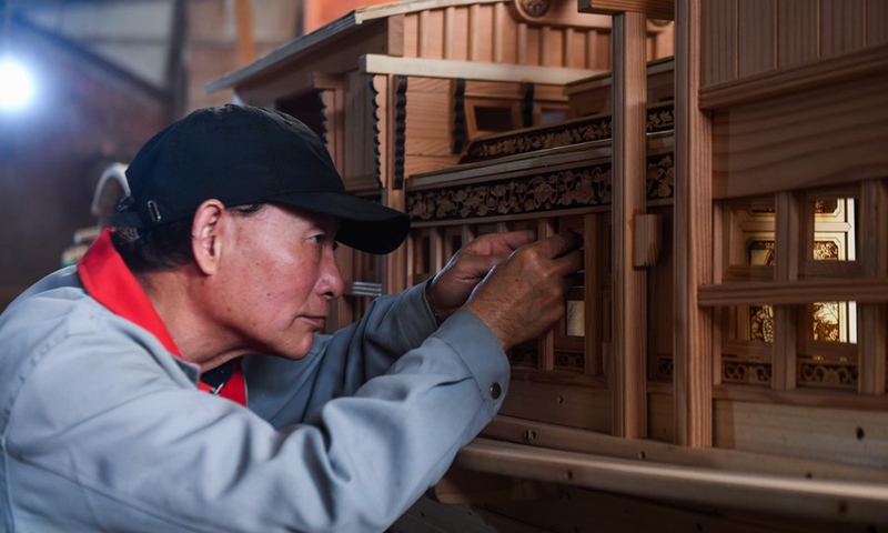 Han Minghua checks a Red Boat model at the workshop of Jiaxing Minghua Ship Model Manufacturing Co., Ltd. in Yuxin Town of Jiaxing City, east China's Zhejiang Province, April 13, 2021.(Photo: Xinhua)