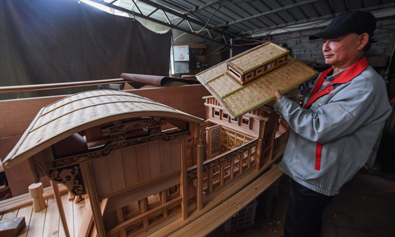 Han Minghua checks a model of the Red Boat at the workshop of Jiaxing Minghua Ship Model Manufacturing Co., Ltd. in Yuxin Town of Jiaxing City, east China's Zhejiang Province, April 13, 2021.(Photo: Xinhua)