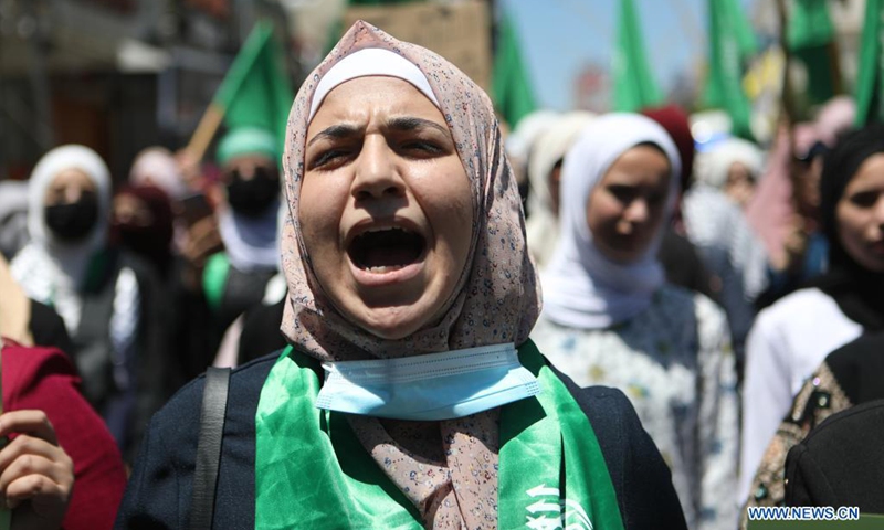 A Palestinian woman takes part in a protest against the continued Israeli airstrikes on the Gaza Strip, in the West Bank city of Hebron, on May 18, 2021.(Photo:Xinhua)