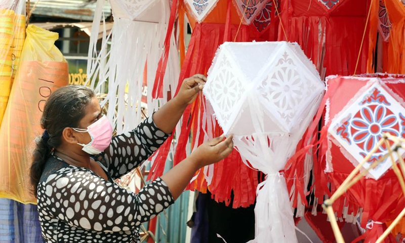 A vendor wearing a face mask prepares to sell lanterns ahead of the Vesak festival in Colombo, Sri Lanka, on May 19, 2021. The Vesak Festival is one of the holiest festivals celebrated in Sri Lanka as it marks the birth, enlightenment and demise of Lord Buddha.Photo:Xinhua