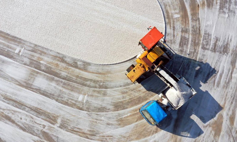 Aerial photo taken on May 18, 2021 shows workers harvesting salt in a salt field at Binhai Township, Zhanhua District, Binzhou City of east China's Shandong Province. Workers have started harvesting spring salt from the 600,000-mu (40,000 hectares) of salt fields at Binhai Township. The total output is expected to hit 500,000 tons when the harvest work concludes by the end of June.Photo:Xinhua