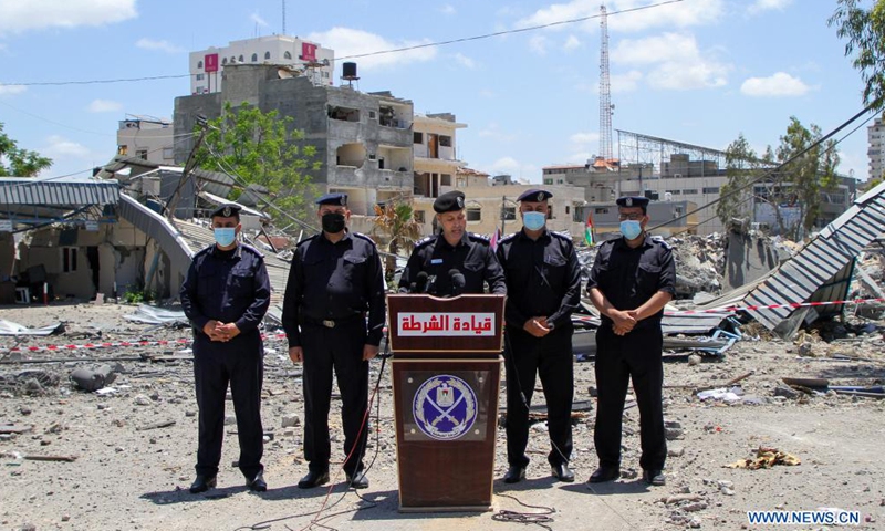 Palestinian policemen of Hamas government are seen in front of the damaged governmental building attacked by Israeli airstrikes in Gaza city, on May 22, 2021.Photo:Xinhua