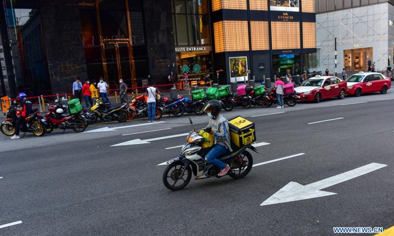 A delivery man wearing face mask rides on a motorbike in Kuala Lumpur, Malaysia, May 22, 2021. Malaysia announced further tightening restrictions on Saturday under its nationwide movement control order (MCO) as the country's accumulative COVID-19 cases topped 500,000.(Photo: Xinhua)