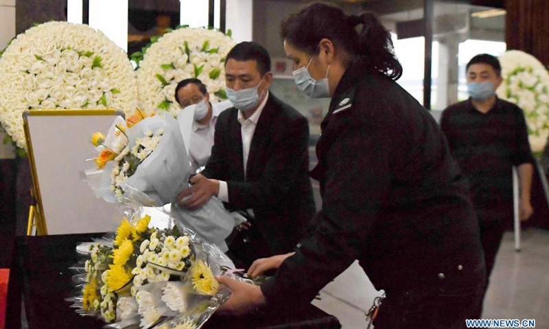 Staff workers place flowers presented by local people to the memorial hall for Yuan Longping at the Mingyangshan funeral parlor in Changsha, central China's Hunan Province, May 22, 2021. The hearse carrying Yuan Longping's body left the Xiangya Hospital of Central South University for funeral parlor in Changsha on Saturday. Halfway through, the hearse made a detour at the Hunan Hybrid Rice Research Center where Yuan lived and worked for a long time.(Photo: Xinhua)