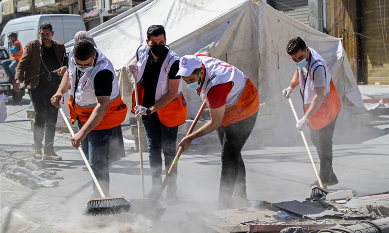 Volunteers clean ruins of destroyed buildings in the Gaza Strip on May 23, 2021.(Photo: Xinhua)