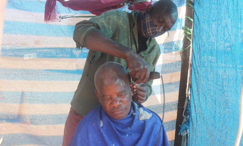 Lekang Botlhoko cuts a customer's hair using a device bought from a Chinese shop in Francistown, Botswana, on May 18, 2021.(Photo: Xinhua)