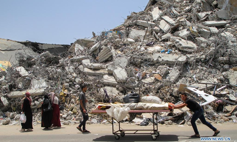 A Palestinian worker removes the rubble of a building destroyed by Israeli air strikes in Gaza City on June 1, 2021. Naji Sarhan, undersecretary of the Hamas-run ministry of public works and housing in the Gaza Strip, told Xinhua that the Israeli bombing of the coastal enclave had destroyed infrastructure including residential buildings, factories and hospitals. It is estimated that 1,100 housing units were completely destroyed, and 900 others were partially destroyed and rendered uninhabitable.(Photo: Xinhua)