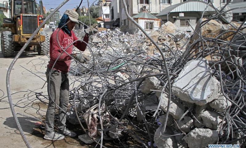 A Palestinian worker removes steel bars from the rubble of a building destroyed by Israeli air strikes in Gaza City on June 1, 2021. Naji Sarhan, undersecretary of the Hamas-run ministry of public works and housing in the Gaza Strip, told Xinhua that the Israeli bombing of the coastal enclave had destroyed infrastructure including residential buildings, factories and hospitals. It is estimated that 1,100 housing units were completely destroyed, and 900 others were partially destroyed and rendered uninhabitable.(Photo: Xinhua)