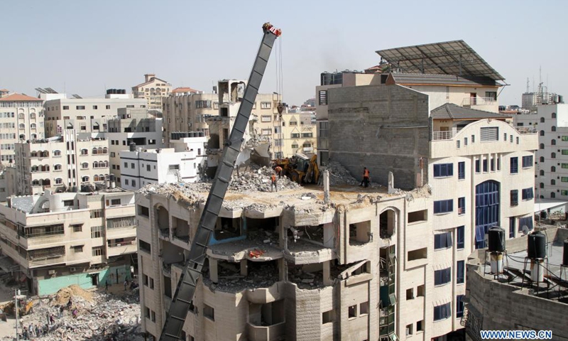 Palestinian workers remove the rubble of a building destroyed by Israeli air strikes in Gaza City on June 1, 2021. Naji Sarhan, undersecretary of the Hamas-run ministry of public works and housing in the Gaza Strip, told Xinhua that the Israeli bombing of the coastal enclave had destroyed infrastructure including residential buildings, factories and hospitals. It is estimated that 1,100 housing units were completely destroyed, and 900 others were partially destroyed and rendered uninhabitable.(Photo: Xinhua)