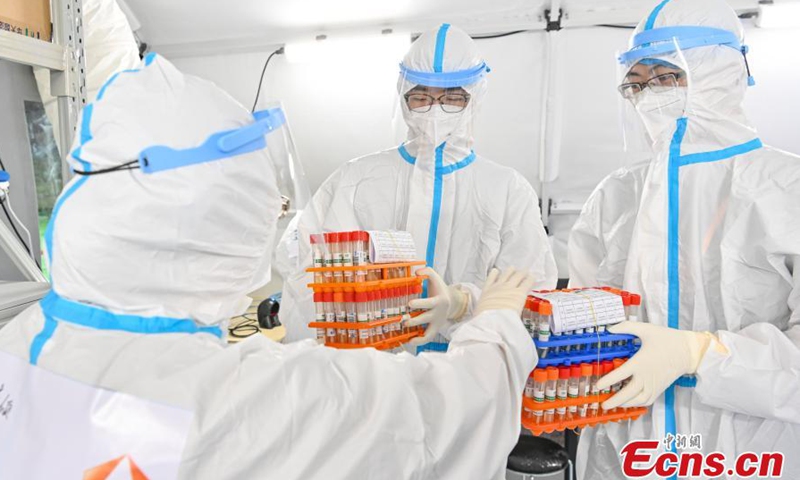 Medical staffs check nucleic acid test samples in an air-inflated mobile COVID-19 test lab set up in Guangzhou Gymnasium, Guangzhou, capital city of south China's Guangdong Province, June 3, 2021.Photo:China News Service