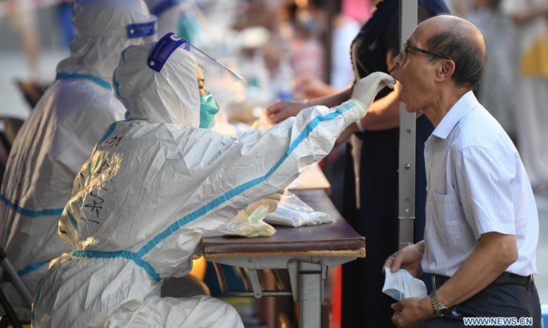 A medical worker collects a swab sample from a resident for COVID-19 nucleic acid testing in Liwan District of Guangzhou, south China's Guangdong Province, June 8, 2021. A new round of mass testing in high-risk areas of Baihedong Street and Zhongnan Street in Guangzhou started on Tuesday.(Photo: Xinhua)