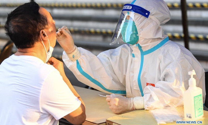 A medical worker collects a swab sample from a resident for COVID-19 nucleic acid testing in Liwan District of Guangzhou, south China's Guangdong Province, June 8, 2021. A new round of mass testing in high-risk areas of Baihedong Street and Zhongnan Street in Guangzhou started on Tuesday.(Photo: Xinhua)