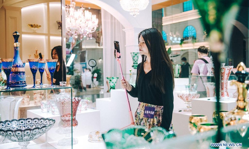 A woman shows crystal items on display through livestreams at the 2nd China-Central and Eastern European Countries (CEEC) Expo in Ningbo, east China's Zhejiang Province, June 8, 2021. The 2nd China-CEEC Expo opened in Ningbo on Tuesday.(Photo: Xinhua)