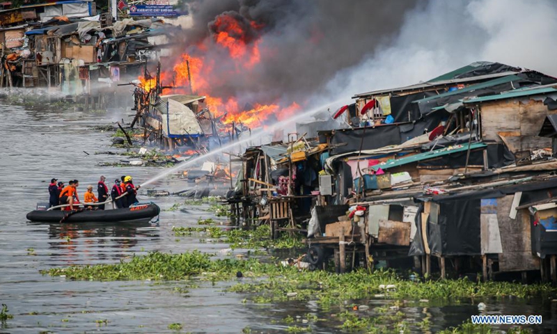 Firefighters and members of the Philippine Coast Guard try to put out a fire engulfing a cargo ship at a wharf in Manila, the Philippines on June 12, 2021. Six crew members were injured and two others unaccounted for when a small cargo ship caught fire while refueling here at a wharf on Saturday morning, the Philippine Coast Guard (PCG) said. (Xinhua/Rouelle Umali)