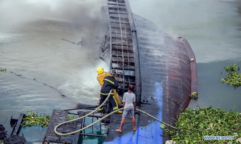 Firefighters try to put out a fire engulfing a cargo ship at a wharf in Manila, the Philippines on June 12, 2021. Six crew members were injured and two others unaccounted for when a small cargo ship caught fire while refueling here at a wharf on Saturday morning, the Philippine Coast Guard (PCG) said. (Xinhua/Rouelle Umali)