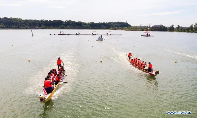 People participate in a dragon boat racing at Quzi Cultural Park in Miluo City, central China's Hunan Province, June 13, 2021. A dragon boat racing performance was held here on Sunday to celebrate the upcoming Dragon Boat Festival. (Xinhua/Chen Sihan)