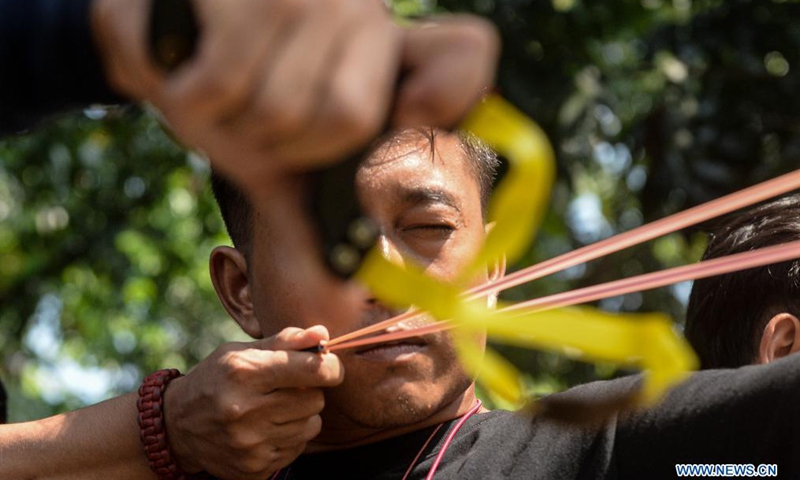 A man participates in a traditional slingshot regional competition held in Jakarta, Indonesia, June 12, 2021.Photo:Xinhua