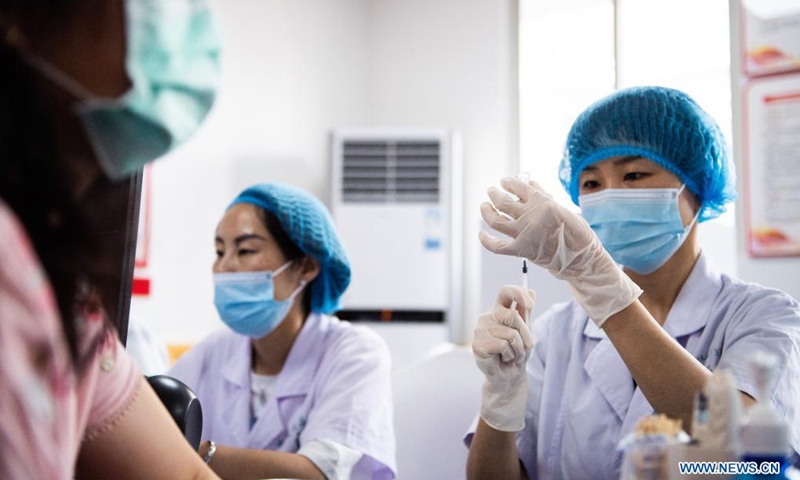 A medical worker prepares a dose of COVID-19 vaccine for a Taiwan compatriot at a community health service center in Changsha, central China's Hunan Province, June 12, 2021. A total of 20 Taiwan compatriots get inoculated with COVID-19 vaccine here on Saturday.Photo:Xinhua