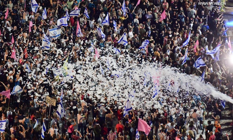 People celebrate after Israel's parliament approved a new coalition government on Rabin Square in Tel Aviv, on June 13, 2021. Naftali Bennett, leader of the right-wing Yamina (United Right) party, was sworn in as new Israeli prime minister on Sunday night, sending Benjamin Netanyahu to the opposition after a record 12-year rule.(Photo: Xinhua)
