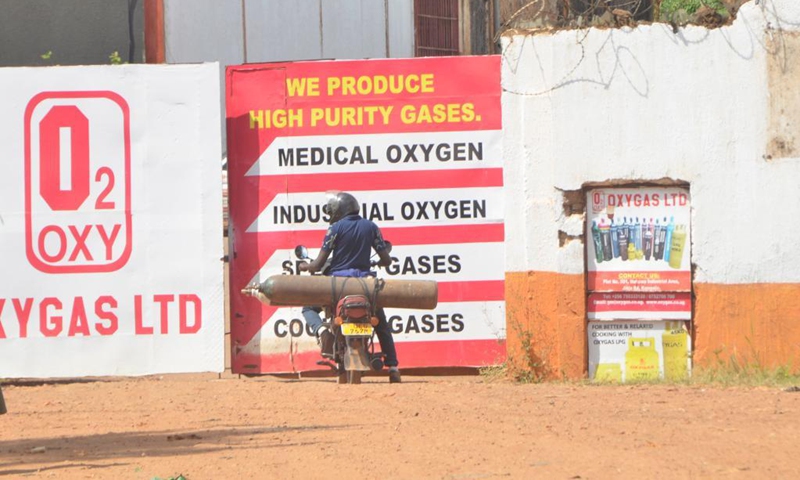 A motorcyclist is seen at the entrance of an oxygen cylinder plant in Kampala, Uganda, June 13, 2021. The Ugandan army has started producing oxygen for state-run hospitals to ease burden of the existing plants as COVID-19 cases keep rising, an army spokesperson said Sunday.(Photo: Xinhua)