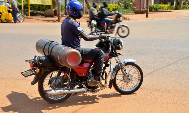 A motorcyclist is seen carrying an oxygen cylinder in Kampala, Uganda, June 13, 2021. The Ugandan army has started producing oxygen for state-run hospitals to ease burden of the existing plants as COVID-19 cases keep rising, an army spokesperson said Sunday.(Photo: Xinhua)