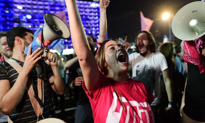 People celebrate after Israel's parliament approved a new coalition government on Rabin Square in Tel Aviv, on June 13, 2021. Naftali Bennett, leader of the right-wing Yamina (United Right) party, was sworn in as new Israeli prime minister on Sunday night, sending Benjamin Netanyahu to the opposition after a record 12-year rule.(Photo: Xinhua)